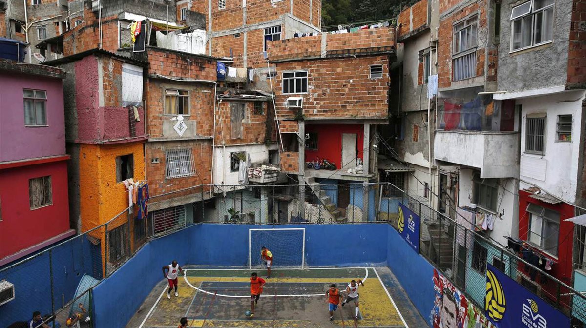 Σε μια συνοικία στο Ρίο της Βραζιλίας, κάποιοι παίζουν έναν αγώνα ποδοσφαίρου σε ένα... συνηθισμένο γήπεδο της γειτονιάς, λίγα χιλιόμτερα μακριά από τα πολυτελή γήπεδα που θα φιλοξενήσουν τους αγώνες του Μουντιάλ. Η Βραζιλία των «δύο ταχυτήτων» σε όλο της το μεγαλείο...